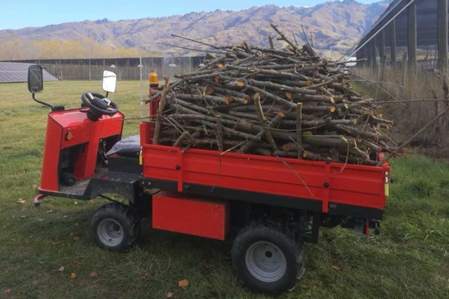 2 men on a pickman PICCA electric work platform and tipper with load of wood in a new zealand orchard